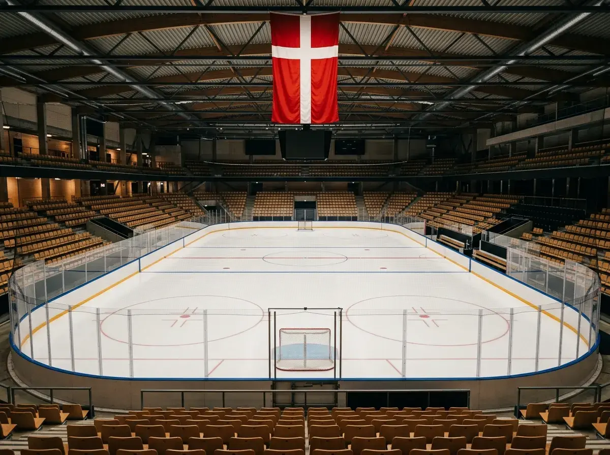 Dansk ishockeyarena med Dannebrog og tom isbane set fra tribunen